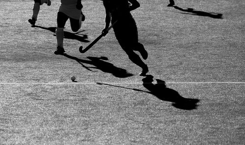 Low section of person playing hockey on field