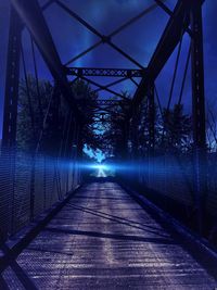 Footbridge against sky at night