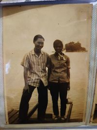 Full length of couple standing against wall