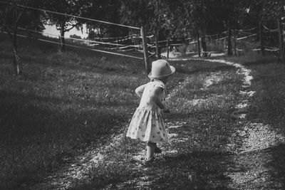 Rear view of woman walking on field