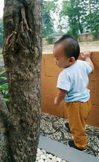 Woman standing on tree trunk