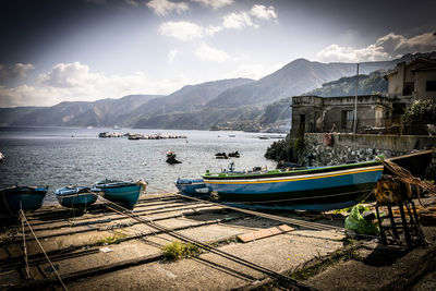 Boats moored in sea against mountains