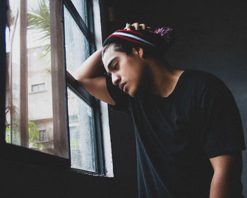 Portrait of young man looking away at home