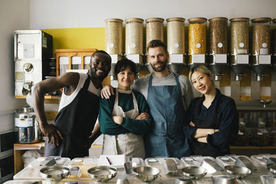 Portrait of smiling male and female multiracial colleagues in food store