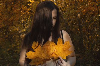 Woman standing on dry leaves during autumn