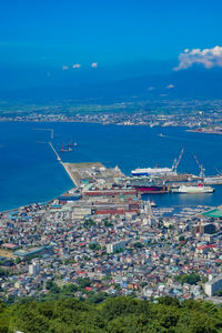 High angle view of townscape by sea against sky