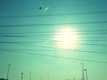 Low angle view of power lines against blue sky