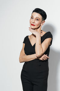 Portrait of young woman standing against white background