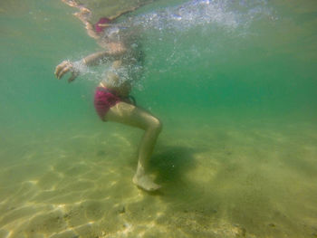 Low section of boy swimming in sea