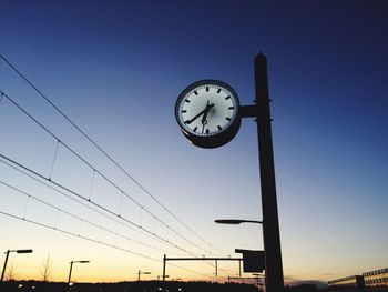 Low angle view of clock against clear sky