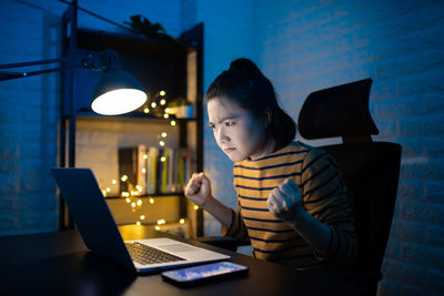 Man using mobile phone while sitting on table