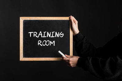 Midsection of man holding blackboard