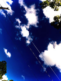 Low angle view of cables against blue sky on sunny day