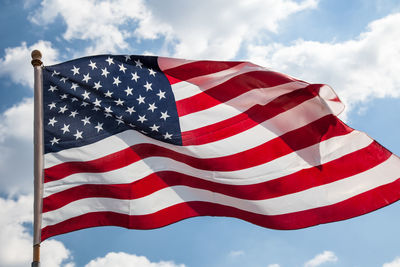 Low angle view of american flag against sky