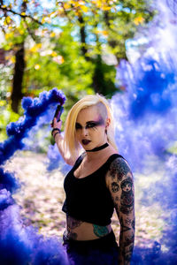 Portrait of young woman with spooky make-up standing outdoors