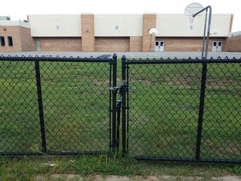 Metal fence on field against building