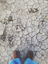 Low section of man standing on barren land