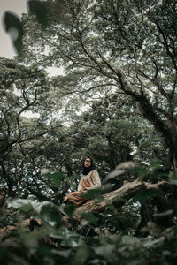 Woman sitting on tree