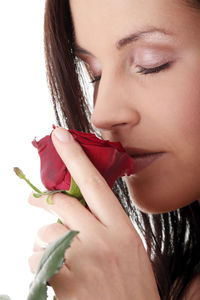 Close-up portrait of woman holding ice cream against white background