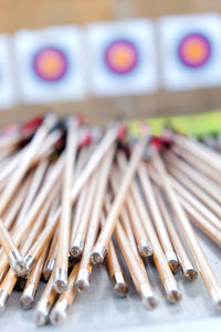 Close-up of arrows on table against archery targets