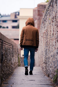 Rear view of woman walking on wall