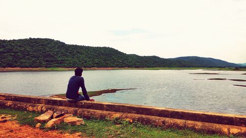 Rear view of man looking at lake