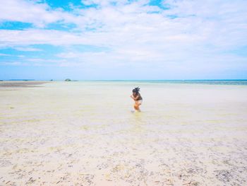 Rear view of woman standing on beach