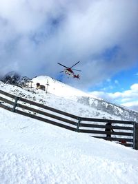 Airplane flying over snowcapped mountains against sky