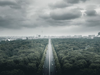 Road amidst buildings in city against sky