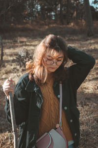 Young woman with arms raised standing in forest