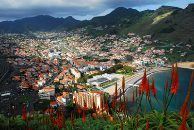 High angle view of townscape and mountains against sky, machico, madeira, portugal 