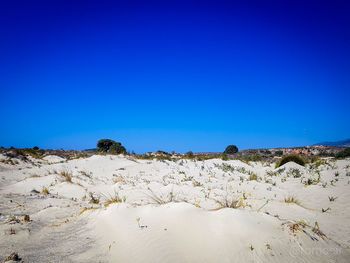 Scenic view of desert against clear blue sky