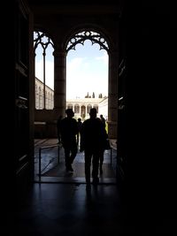 Rear view of silhouette men walking in corridor