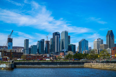 City at waterfront against blue sky