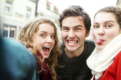 Three playful friends taking a selfie