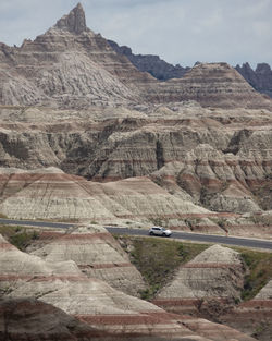 Car driving through unreal rock formations and badlands landscape