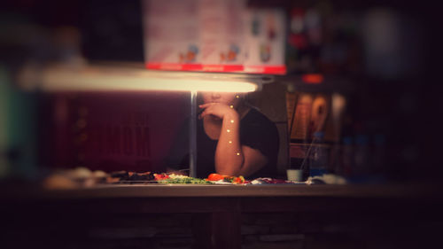 Midsection of woman with drink on table in restaurant