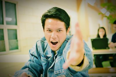 Portrait of university student gesturing in classroom