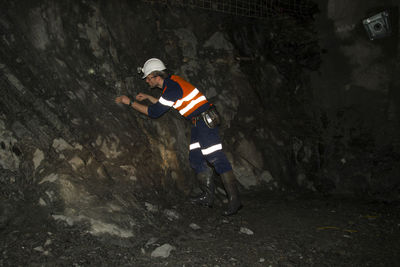 Geologist examining rock formation in cave