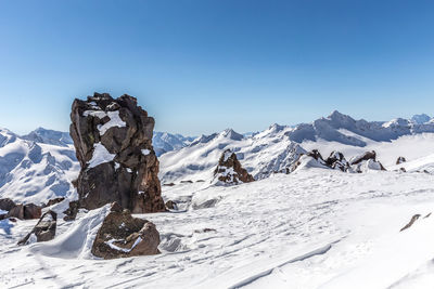 Scenic view of snowcapped mountains against clear blue sky