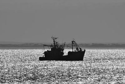 The shape of a fishing boat going out for work at the golden hour. keep calm and go fishing.