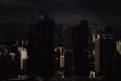 Modern buildings in city against sky at night