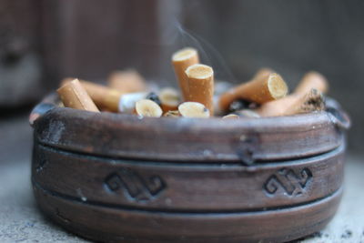 Close-up of cigarette butts in ashtray on table