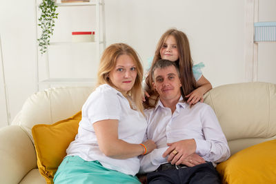 Portrait of friends sitting on sofa at home