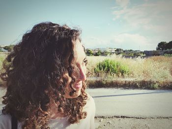 Close-up of thoughtful woman against sky