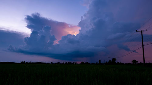 Scenic view of agricultural field against sky at sunset