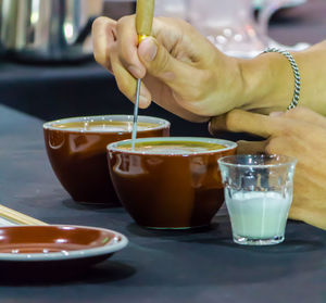 Midsection of woman holding drink on table