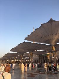 Group of people in city against clear sky