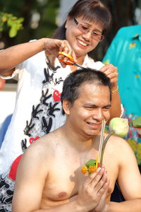 Mother cutting son hair during ceremony