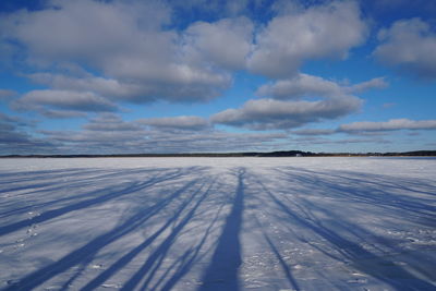 Scenic view of snow covered land against blue sky